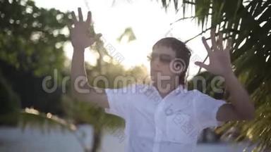 <strong>太阳落山</strong>时，戴着<strong>太阳</strong>镜在热带丛林中享受度假舞蹈的英俊年轻人的肖像。 1920x1080。